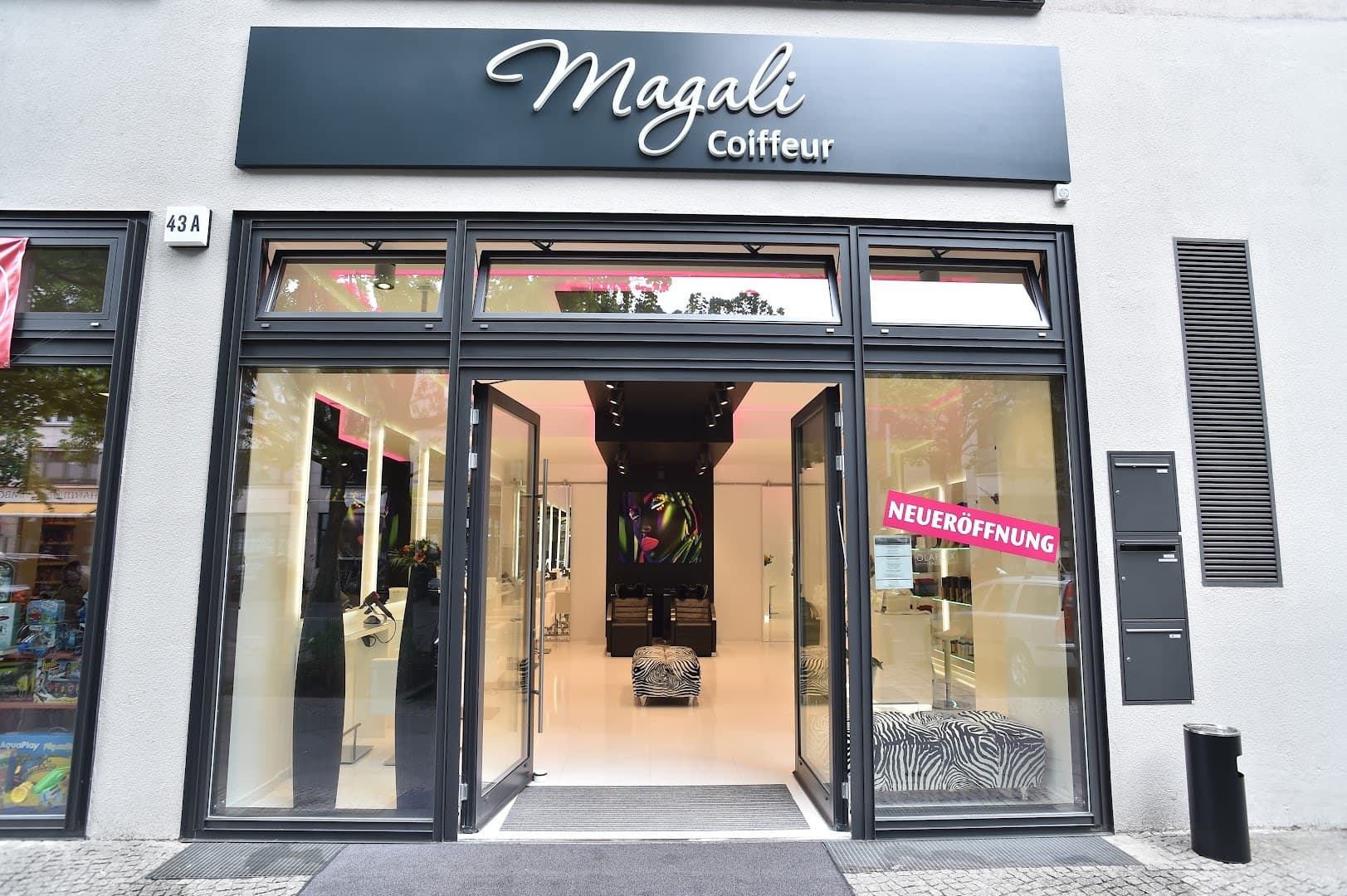 Eingang des Salons Magali Coiffeur mit Schriftzug über der Glastür