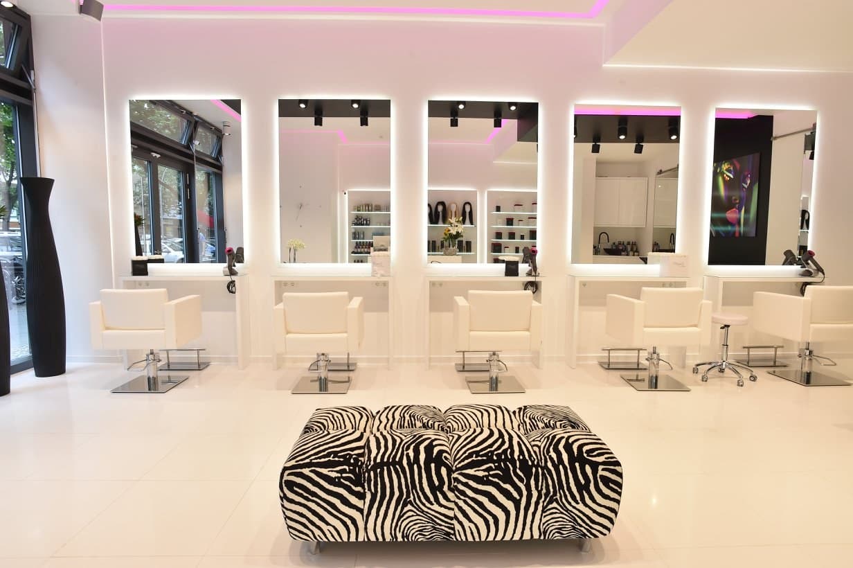 Spiegelplätze mit weissen Sesseln und Zebra-Bank im hellen Salon