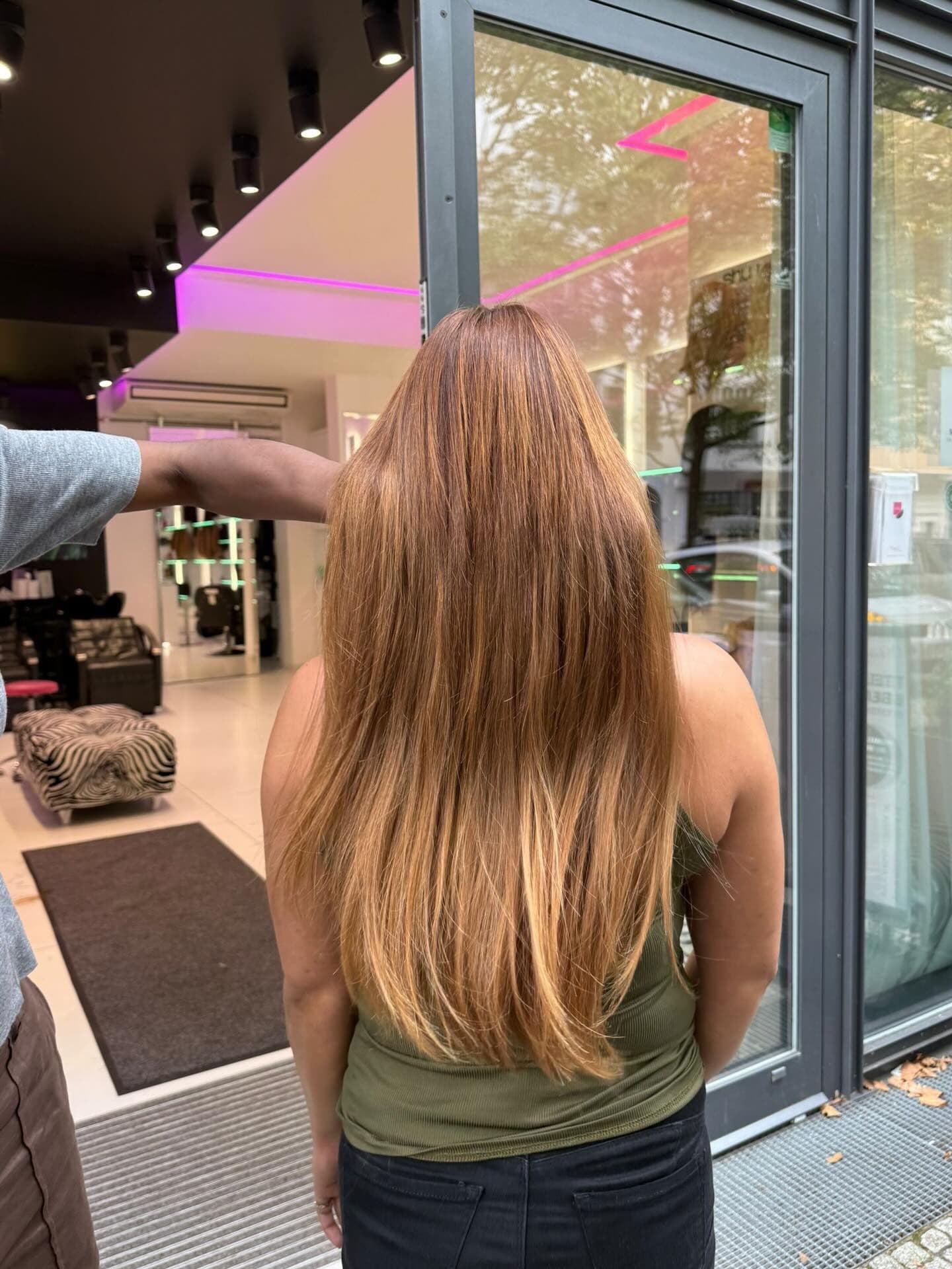 Lange kupferblonde Längen, Rückansicht an der Salontür